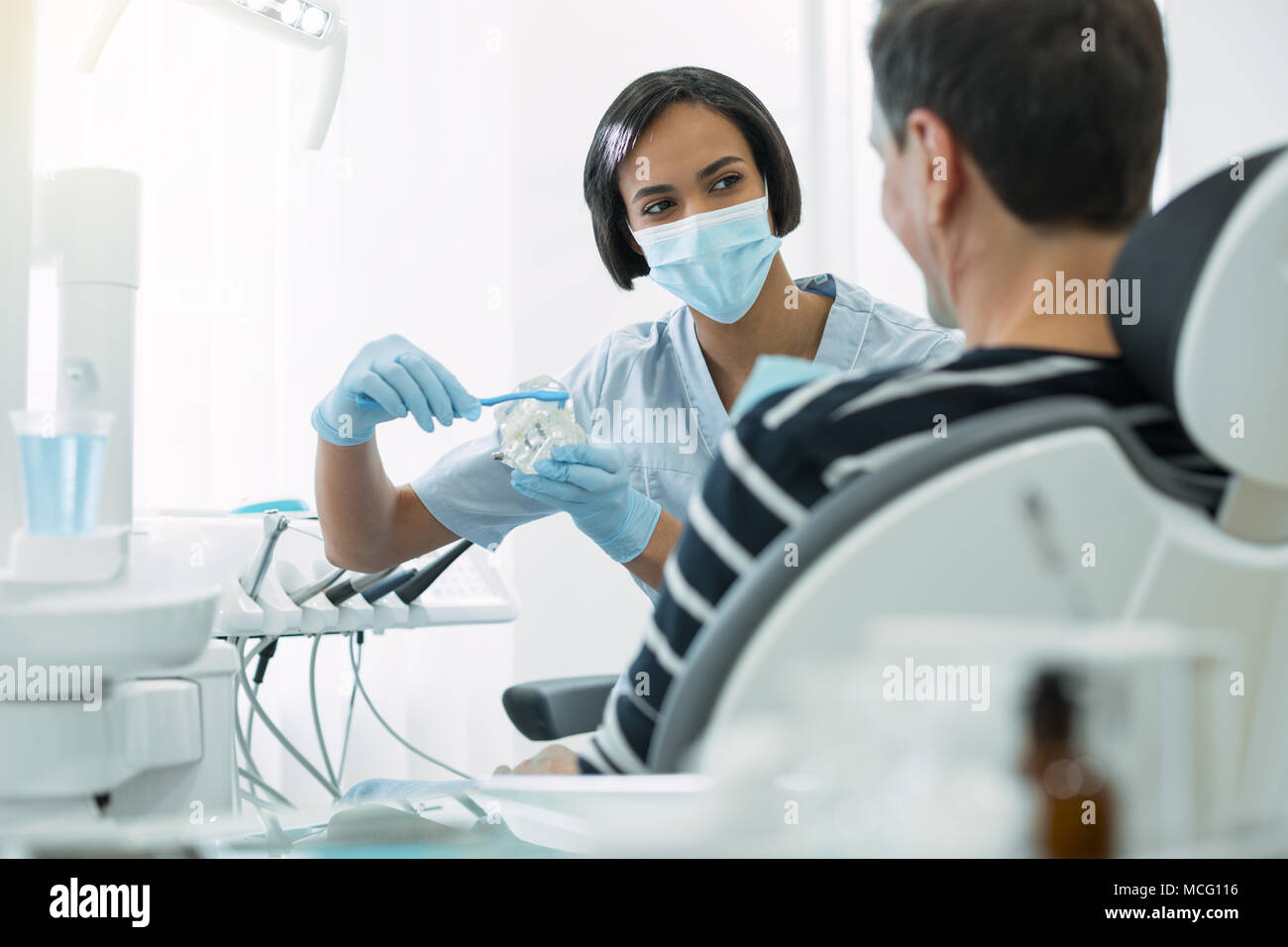 Inspired dentist showing how to brush teeth correctly Stock Photo Alamy