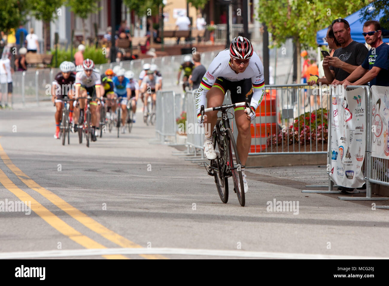 Duluth, GA, USA - August 2, 2014:  A male cyclist separates himself from a group of racers competing in the Georgia Cup Criterium event. Stock Photo