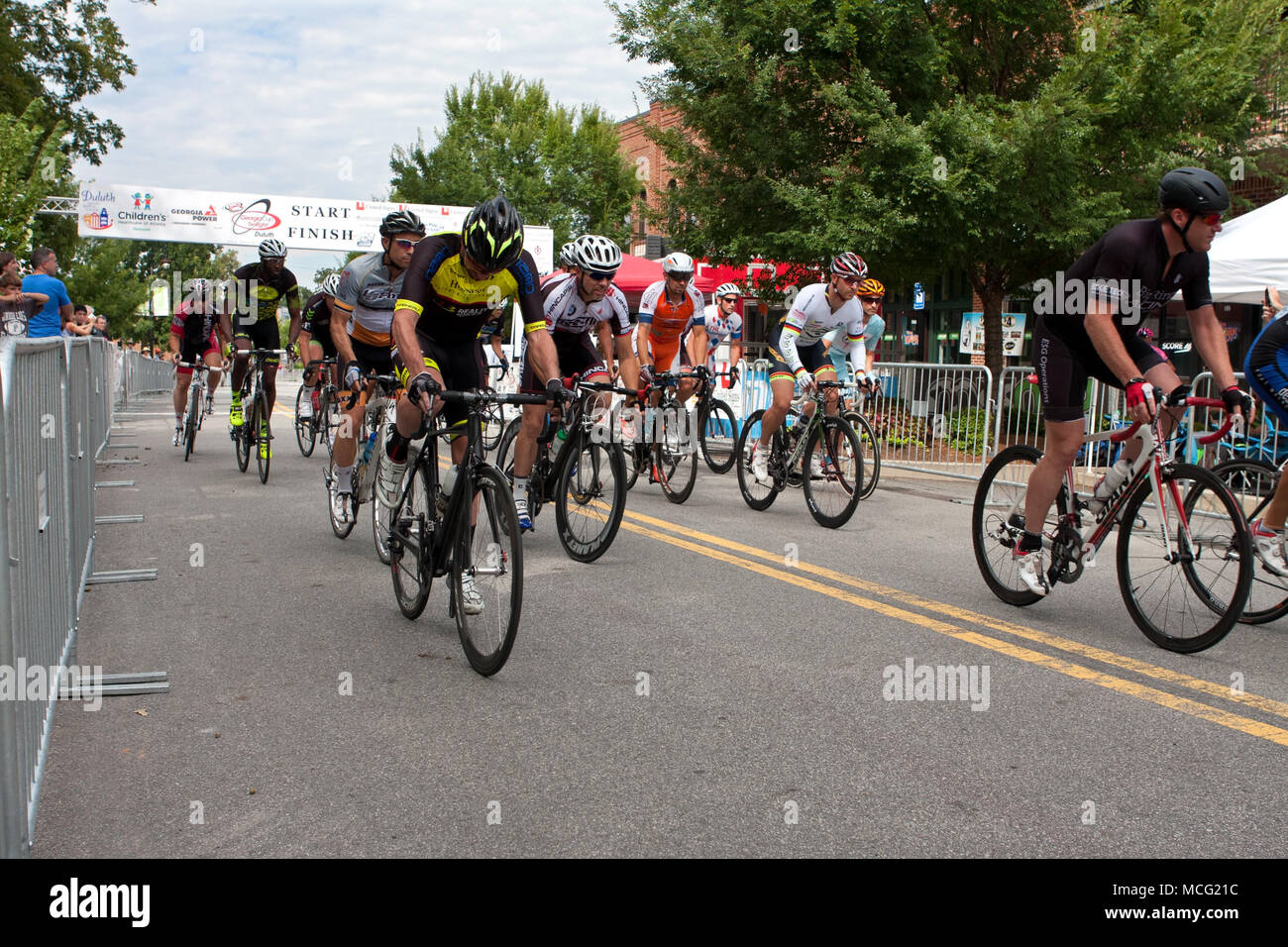 Duluth, GA, USA - August 2, 2014:  A group of cyclists sprint from the starting line as they compete in the Georgia Cup Criterium event. Stock Photo