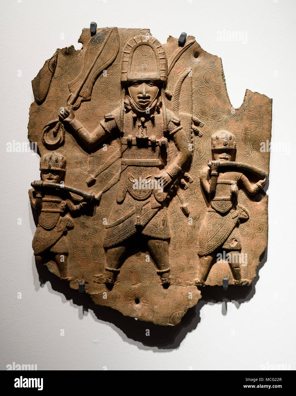 Berlin. Germany. Benin Bronzes. High-ranking dignitary with sword and rectangular bell accompanied by two hornblowers, brass plaque. 16-17th century.  Stock Photo