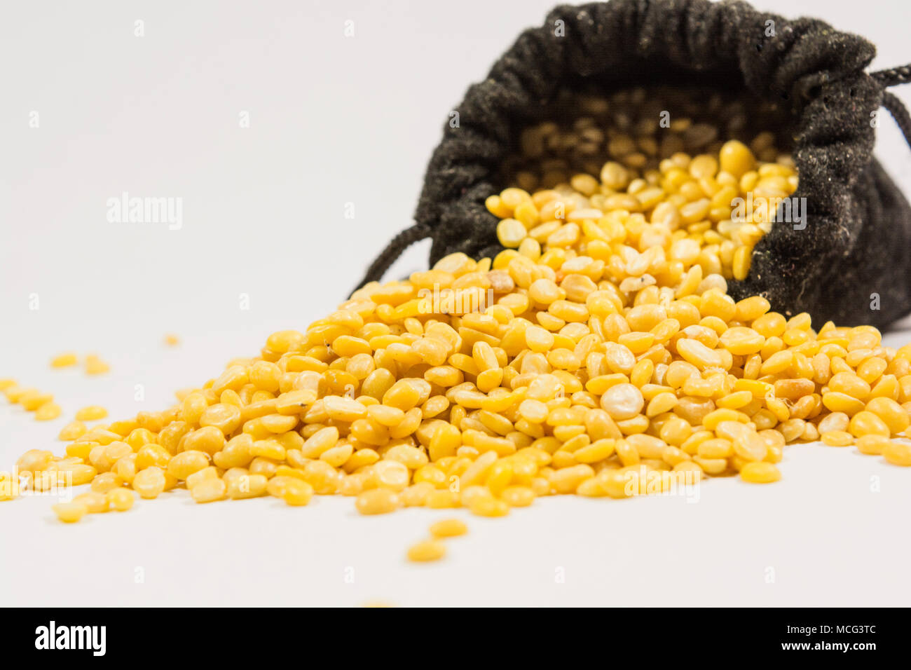 Split black grma seeds in black bag on isolated white background Stock Photo