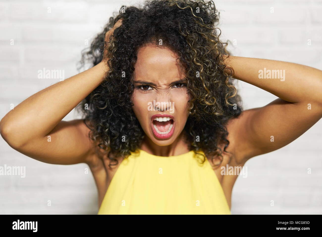Facial Expressions Of Young Black Woman On Brick Wall Stock Photo