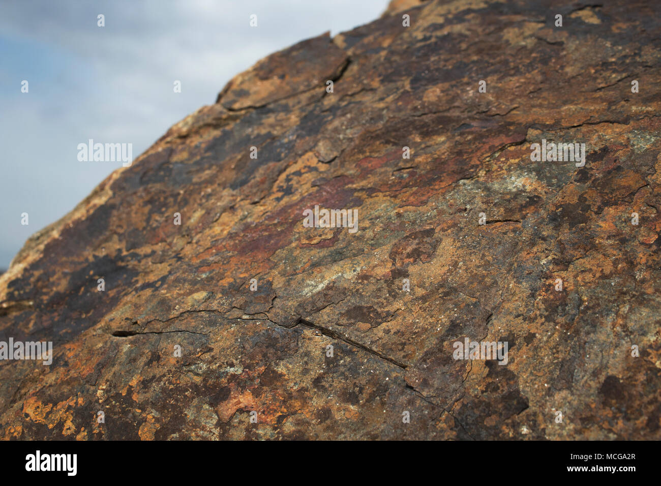 Brown stone against the sky. Grunge stone. Natural stone background. Stock Photo