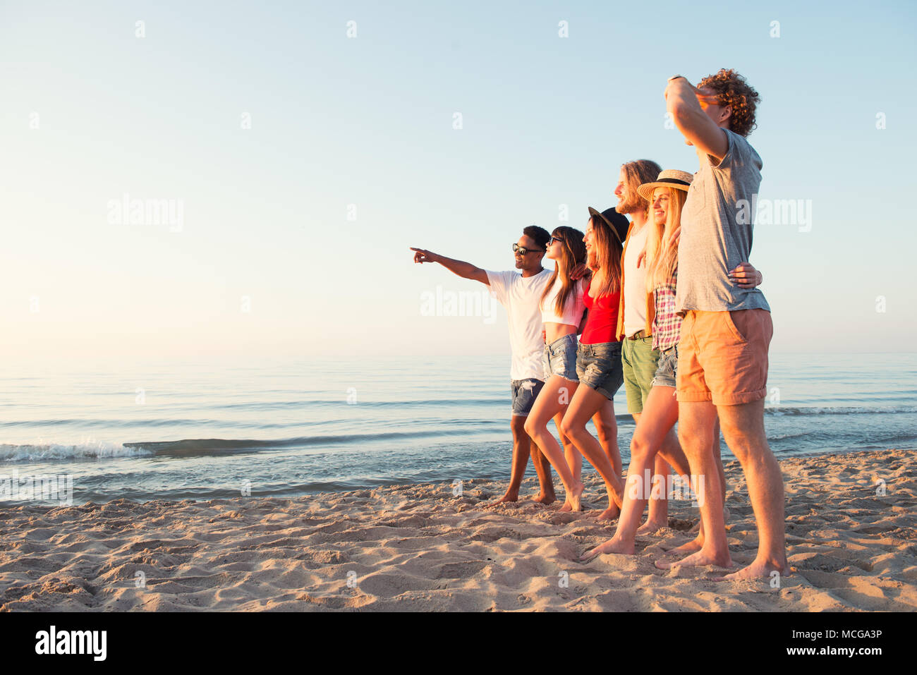 Group of happy friends having fun at ocean beach Stock Photo
