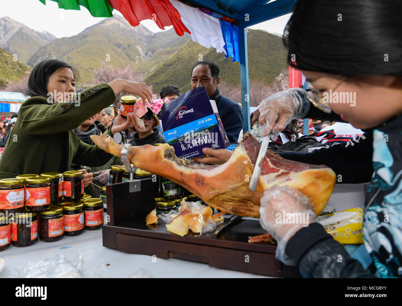 Nyingchi, China's Tibet Autonomous Region. 15th Apr, 2018. People taste air-dry pork during a kick-off ceremony for tourism season in Gongbo'gyamda County, southwest China's Tibet Autonomous Region, April 15, 2018. Credit: Liu Dongjun/Xinhua/Alamy Live News Stock Photo