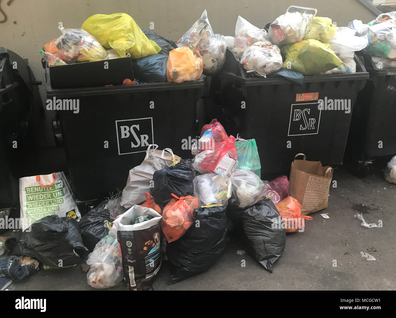 10 April 2018, Germany, Berlin: Waste containers spill over with trash on a residential premises in th Kreuzberg district of Berlin. Photo: Paul Zinken/dpa Stock Photo