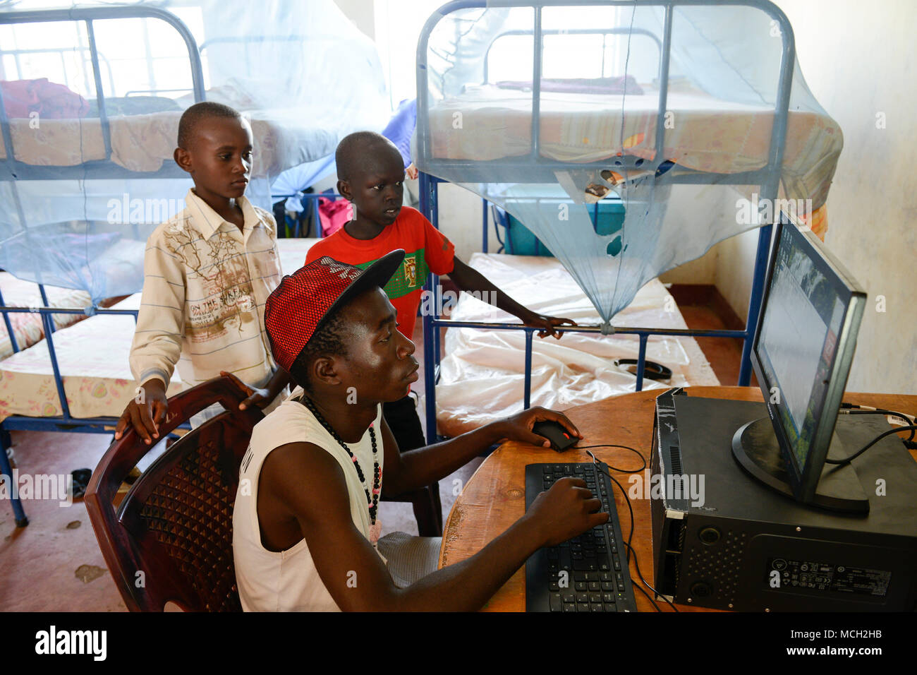 KENYA, Turkana, refugee camp Kakuma IV, JRS Jesuit refugee Service, shelter for children / KENIA, Turkana, Fluechtlingslager Kakuma 4, JRS Jesuit refugee Service, Kinderschutz Zentrum, playing at computer Stock Photo