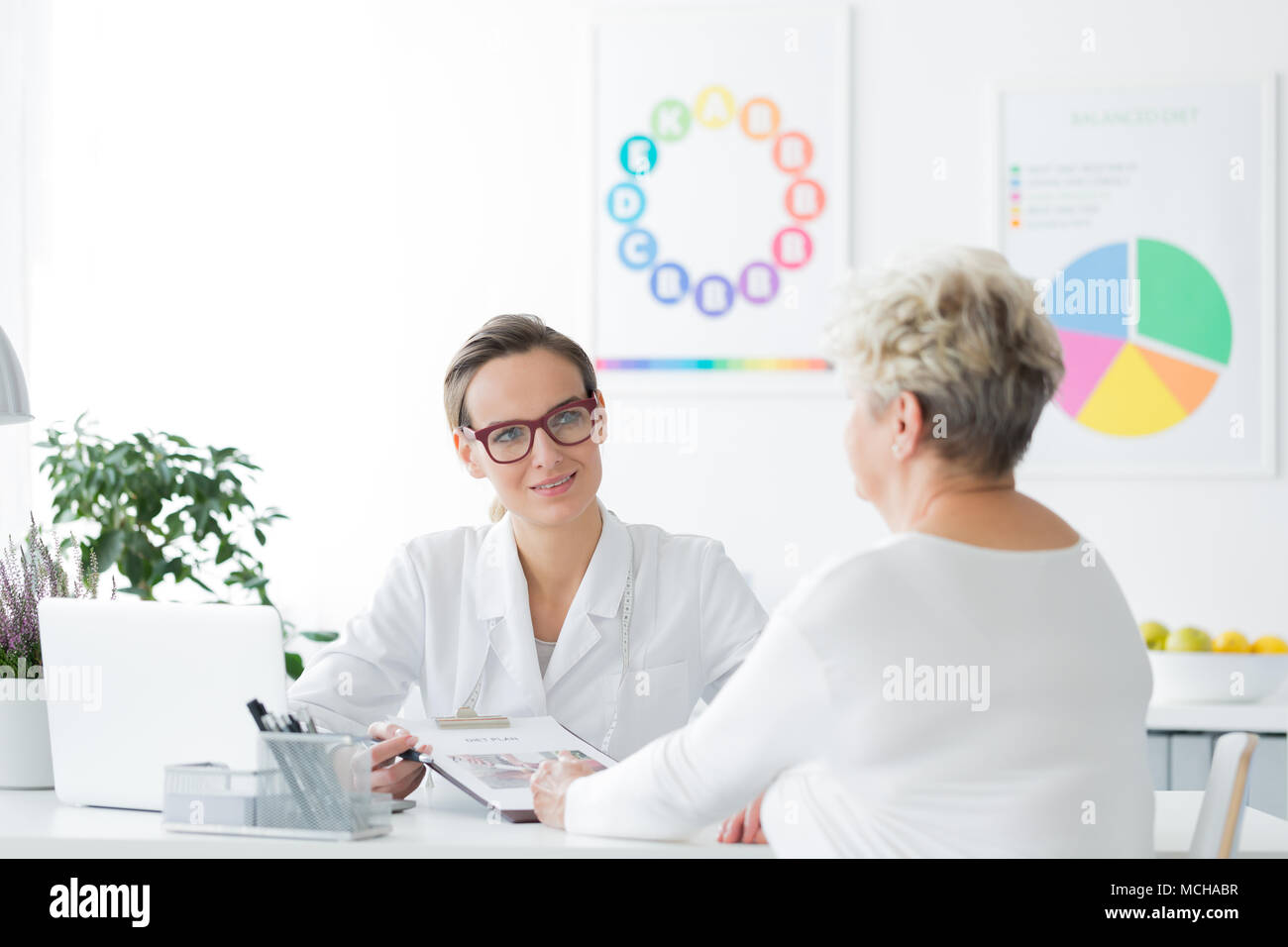 Doctor planning a weight loss diet plan together with her elderly