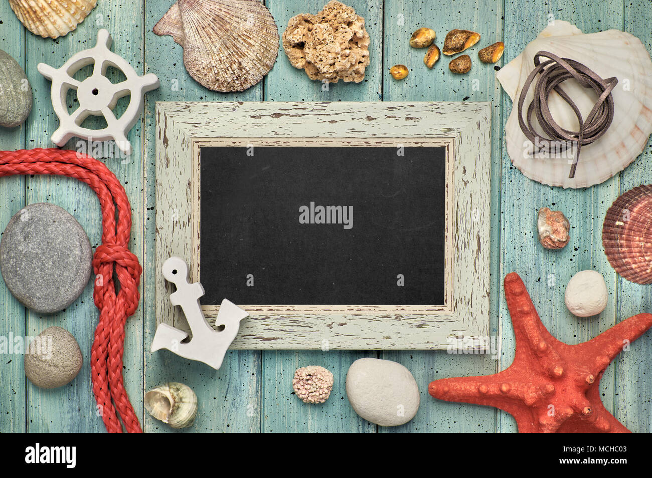 Blank blackboard with sea shells, rope, anchor and star fish on light wood, text space Stock Photo
