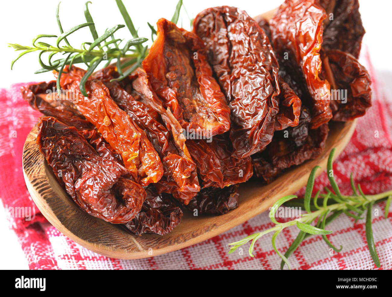 bowl of sun dried tomatoes with rosemary on checkered dishtowel - close up Stock Photo