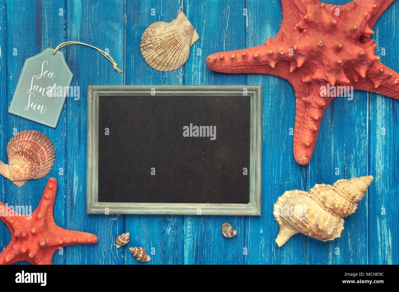 Blank blackboard with sea shells, rope and star fish on blue wood, text space Stock Photo