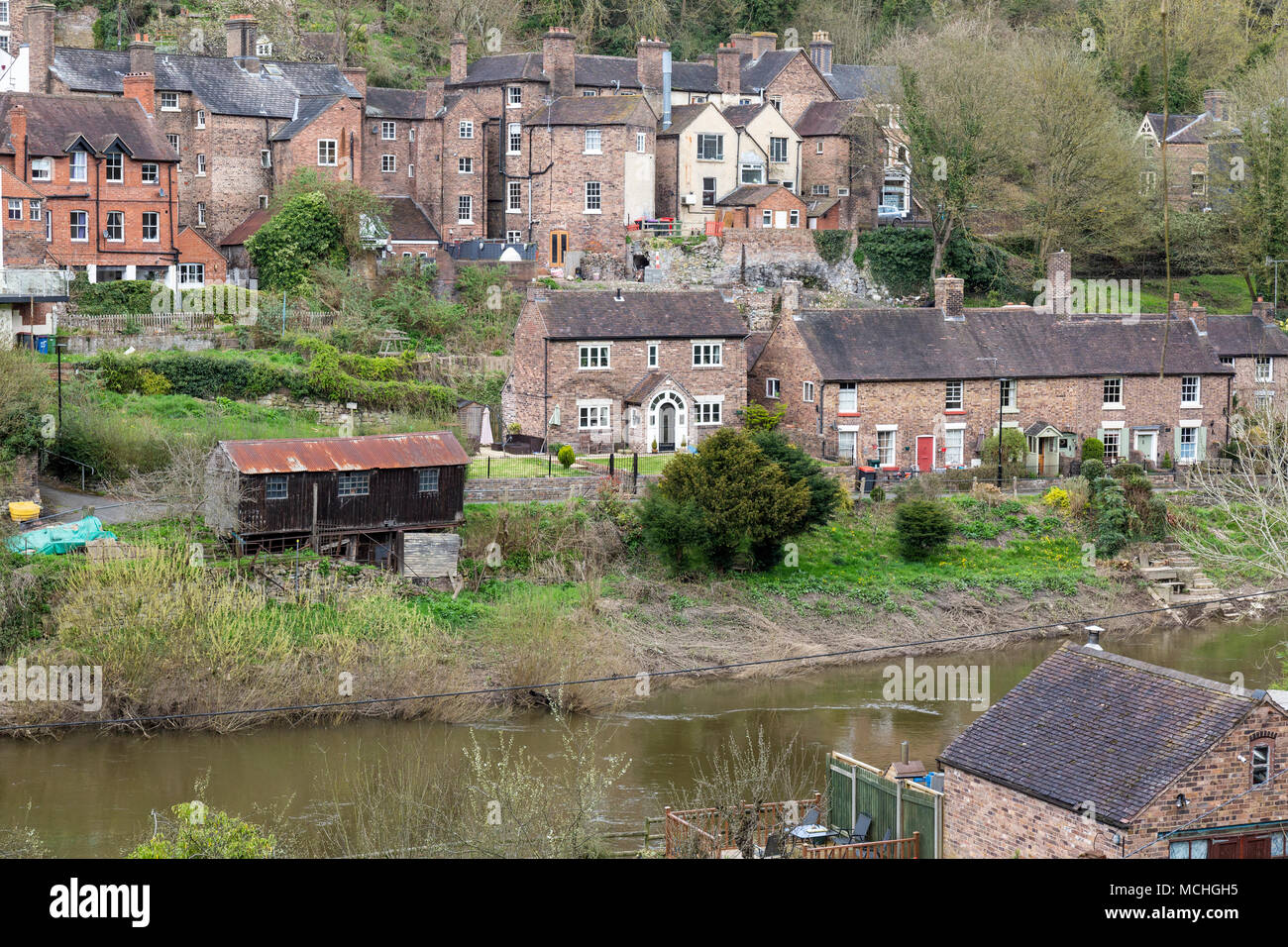 Houses on the banks of the River Severn in Ironbridge, Shropshire, England. The shed used to build coracles, and owned by the Rogers family, to left. Stock Photo