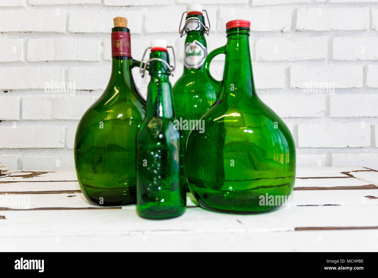 Vintage green glass bottles on an old white washed table Stock Photo