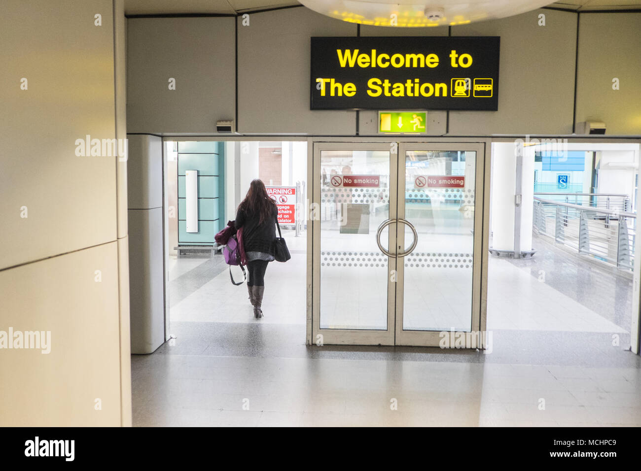 Traveller,passenger,walking,from,Manchester,Airport,terminal,building