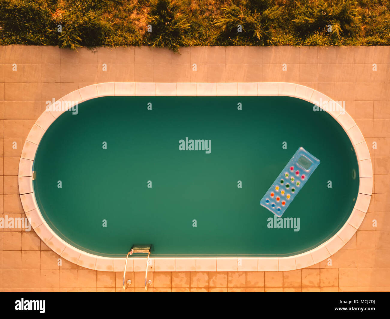 Aerial view of inflatable mattress in swimming pool - summer fun and enjoyment leisure activity equipment in the poolside water from drone point of vi Stock Photo