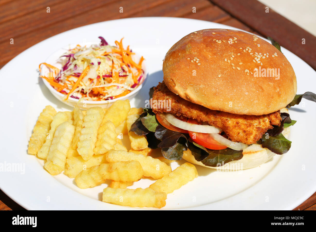 A delicious crispy fish burger with cheese, lettuce, and mayonnaise