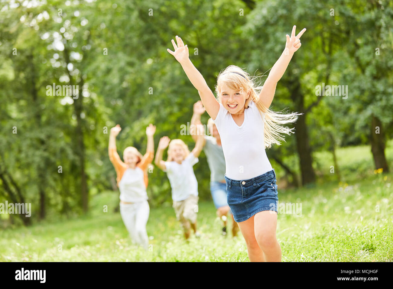 Blonde girl happily cheers on a family outing Stock Photo