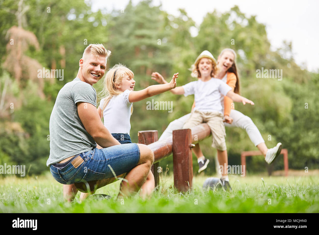 Father plays and rocks with children on the playground in the park Stock Photo
