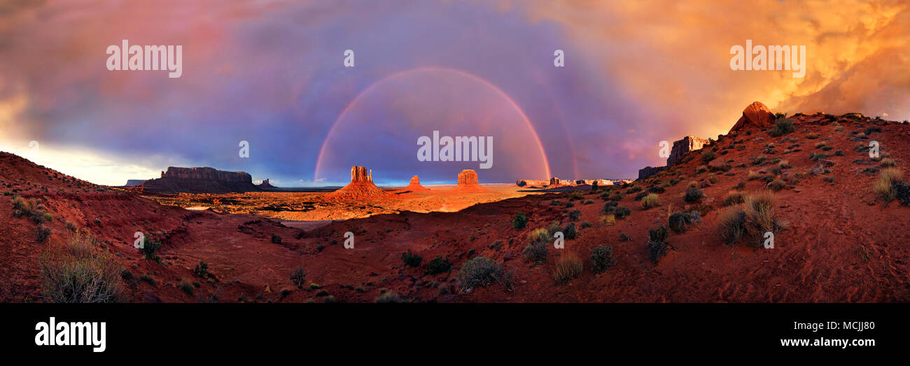Panorama with Sentinel Mesa, West Mitten Butte, East Mitten Butte and Merrick Butte, with Rainbow, Monument Valley Stock Photo