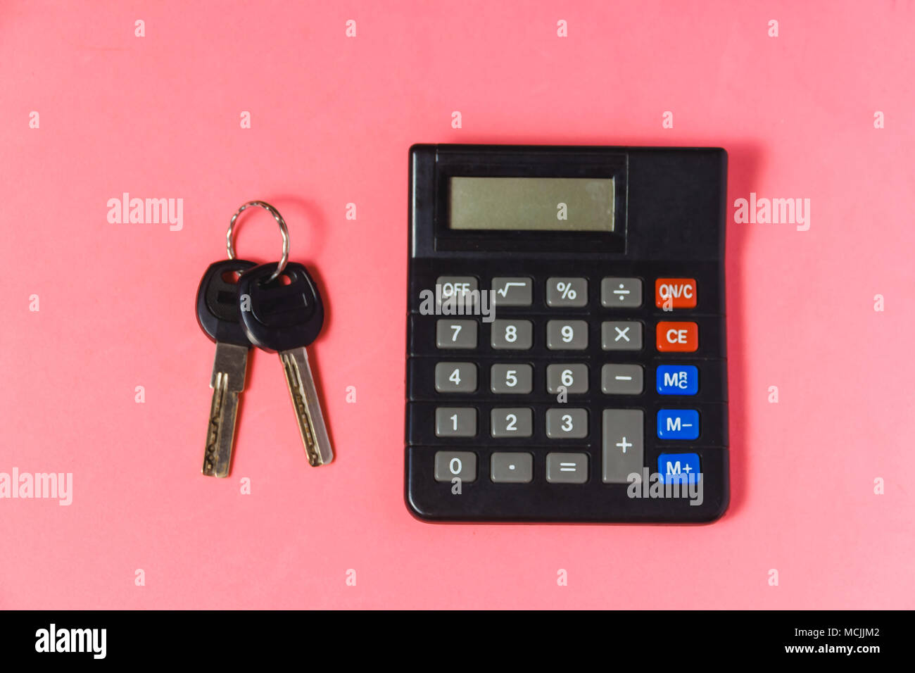 Mortgage Loans Concept with Key, Paper House and Calculator on Pink Background Stock Photo