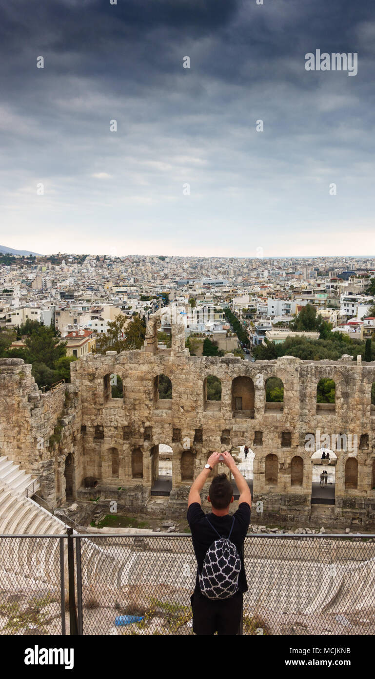 Tourist photographing Odeon of Herodes Atticus and Cityscape using mobile camera, Athens, Greece Stock Photo