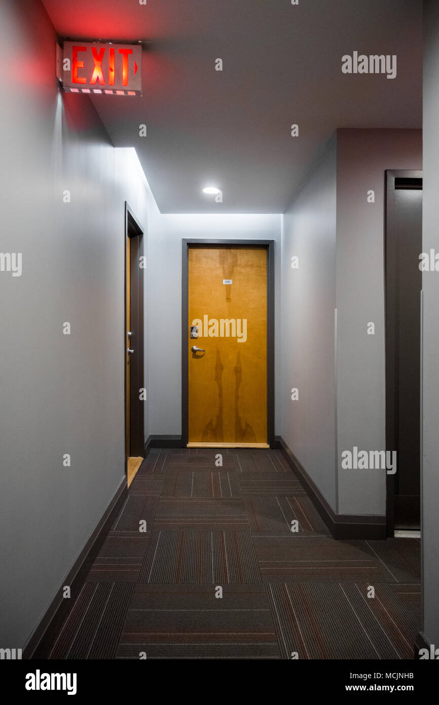 Illuminated corridor with closed doors and exit sign Stock Photo Alamy