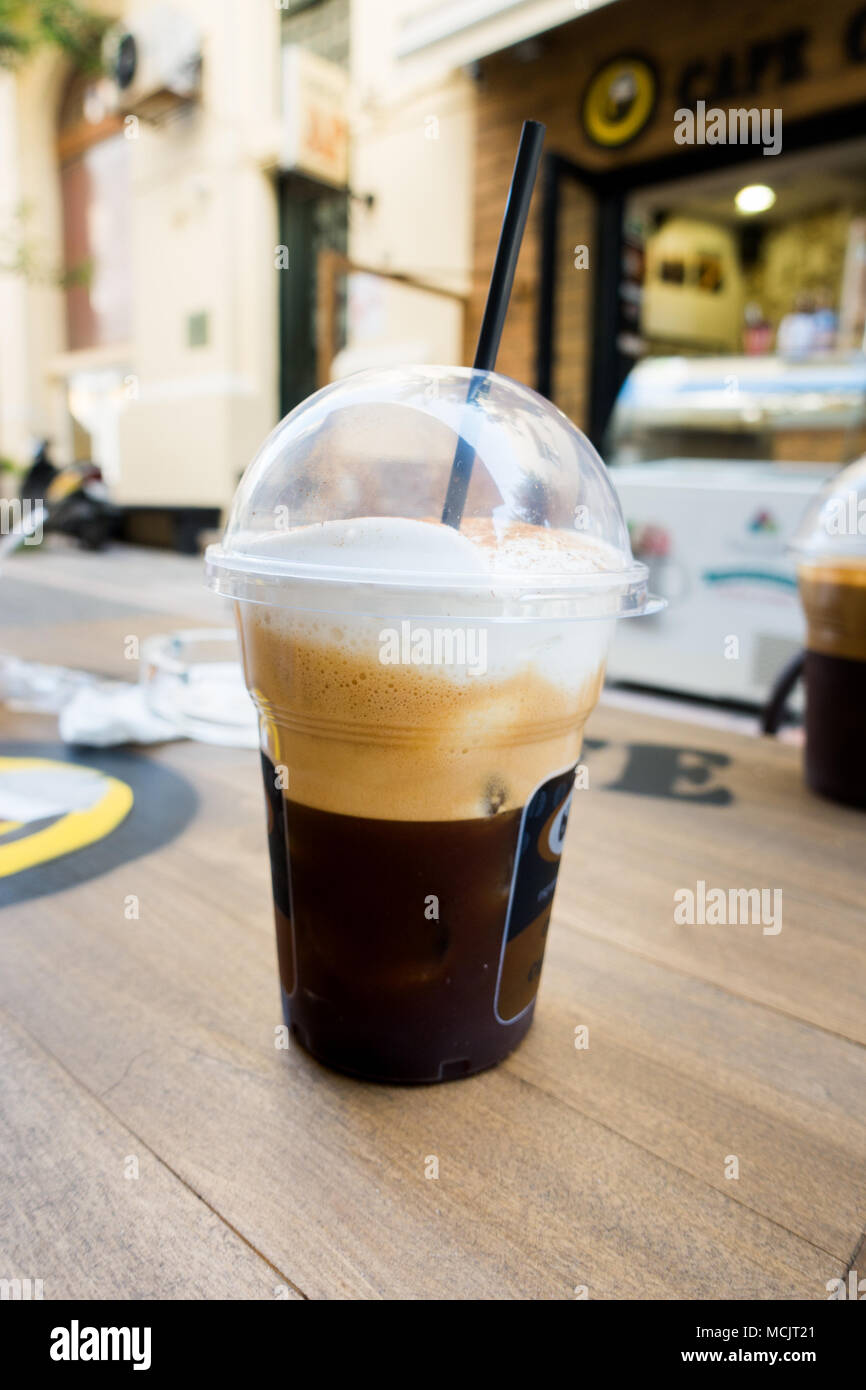 Disposable coffee cup on table of sidewalk cafe, Heraklion, Greece