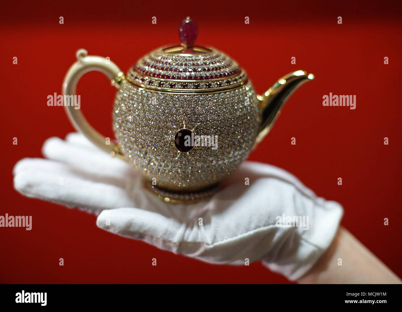 A member of the curatorial team shows off The Egoist in London, ahead of National Tea Day. Named by Guinness World Records in 2016 as the world's most valuable teapot at 3 million US Dollars (&pound;2,307,900), it was designed by Nirmal Sethia, Chairman of Newby Teas, and inspired by his late wife Chitra, who passed away in 2010. Stock Photo