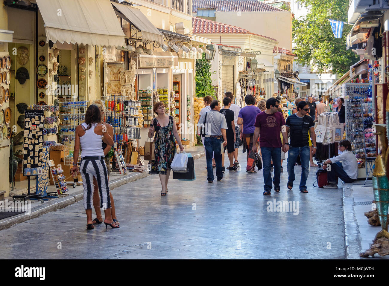 Tourists shop and stroll in the narrow cobblestone streets of Plaka - Athens, Greece Stock Photo