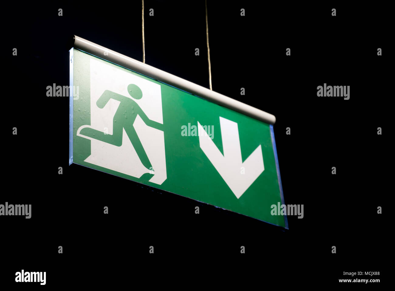 Emergency exit sign hanging on a wall. Emergency exit sign in a