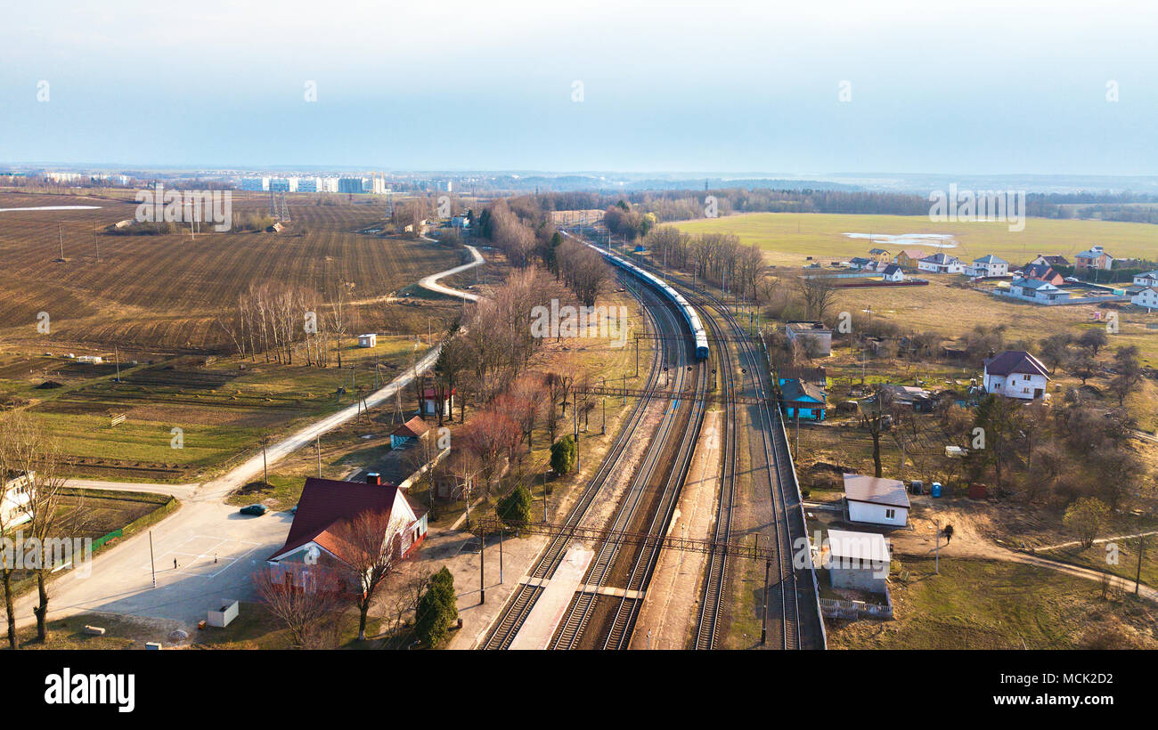 Top perspective view on railway lines. Train in the countryside. aerial view of railway station. Train passing to a distance at the double line railwa Stock Photo