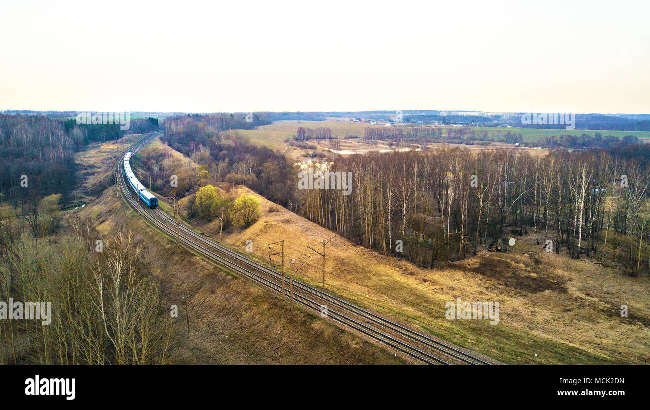 Top perspective view on railway lines. Train in the countryside. Train passing to a distance at the double line railway Stock Photo