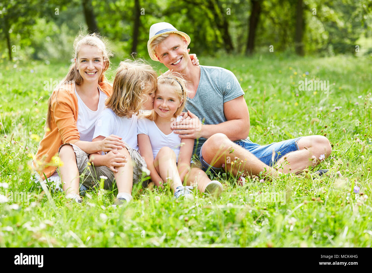 Loving siblings with parents together in the summer in the garden Stock Photo