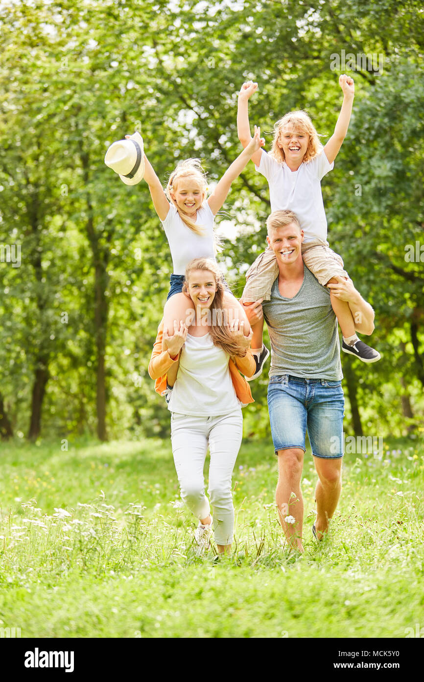 Children ride piggyback on their parents' backs and cheer Stock Photo