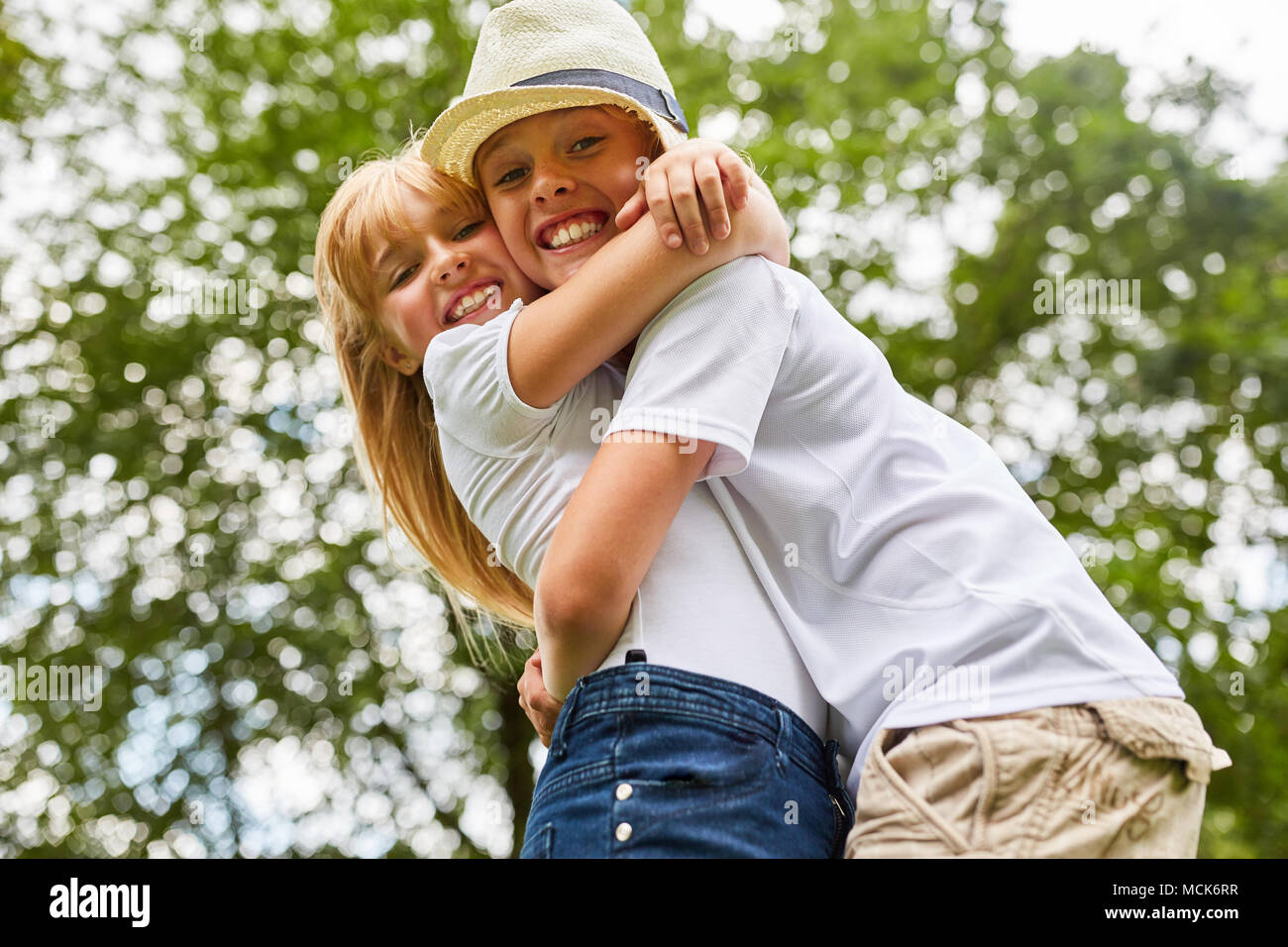 Brother and sister hugging each other happily while reunion in the countrys...