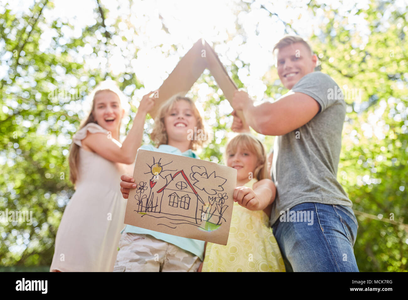 Family and children with home drawing as a vision for the future Stock Photo