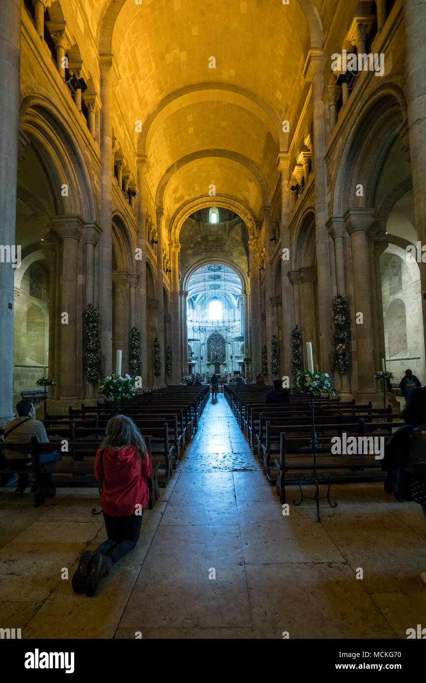 faithful pray in the Cathedral of Sé in Lisbon, Portugal Stock Photo