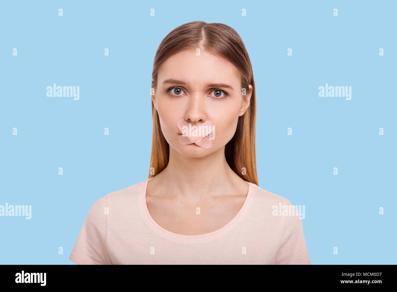 Woman with her mouth sealed with bandage hires stock photography and