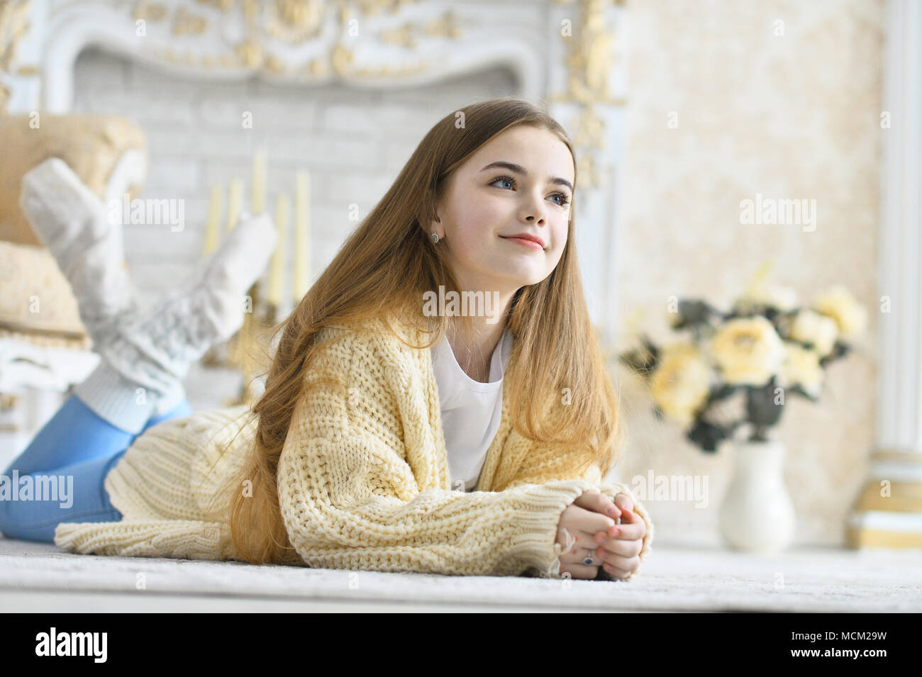 Beautiful teen girl lying on floor in room Stock Photo - Alamy