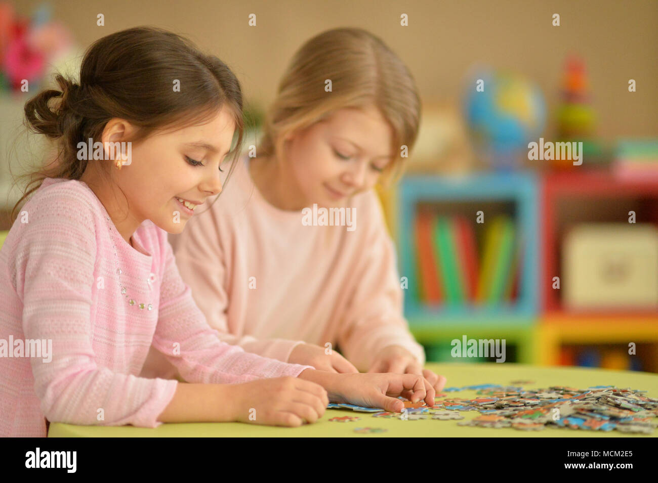 Girls collecting puzzles Stock Photo