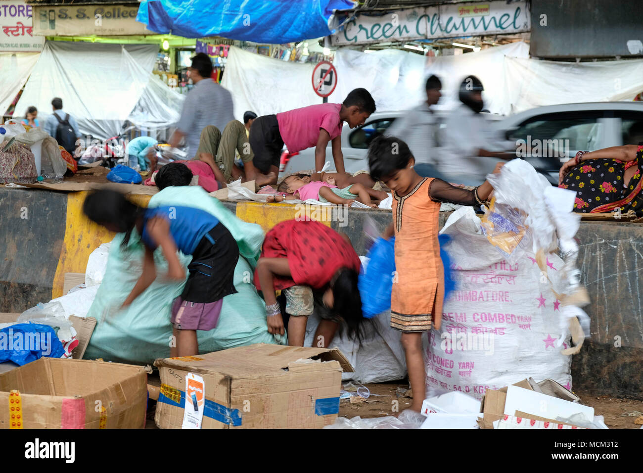 Street children working collecting cardboard and garbage in downtown Mumbai, India Stock Photo