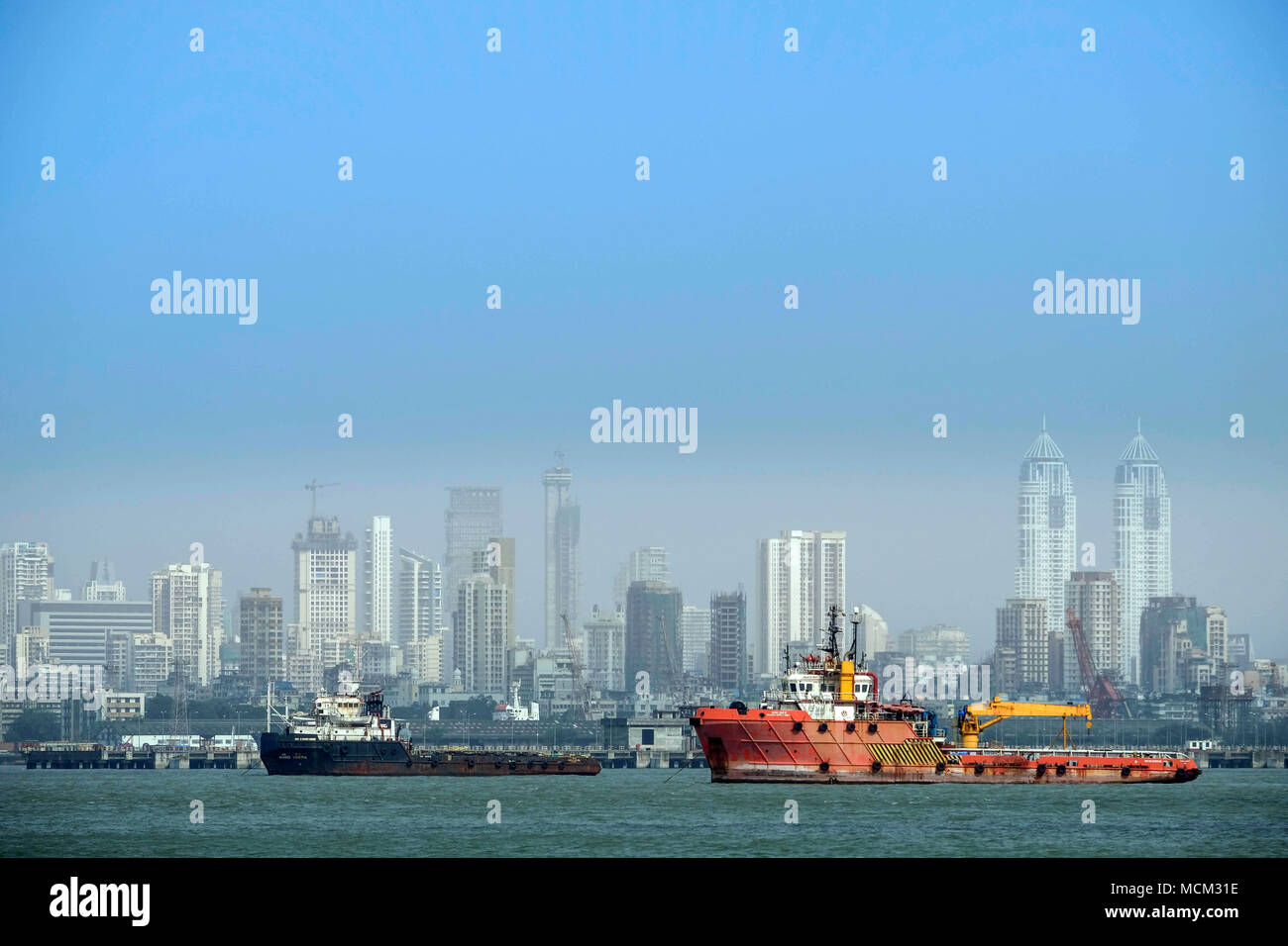 View of tug boats in Back Bay off Norman point with the skyscrapers of Colaba and modern Mumbai in the background. Port of Mumbai Stock Photo