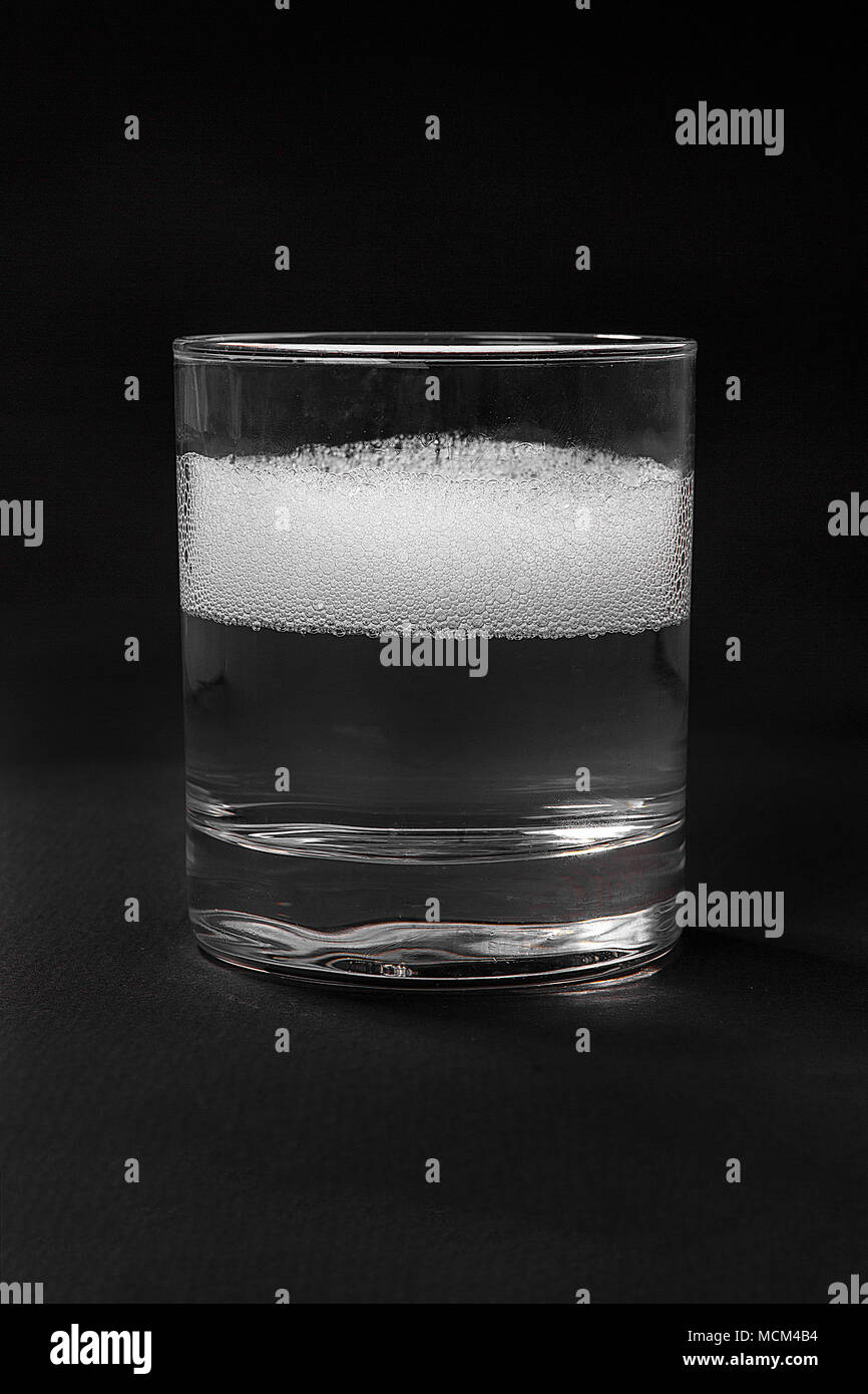 Monochrome transparent cocktail, soda, foam, boom, in a low glass. Side view Isolated black background. Drink for the menu restaurant, bar, cafe Stock Photo