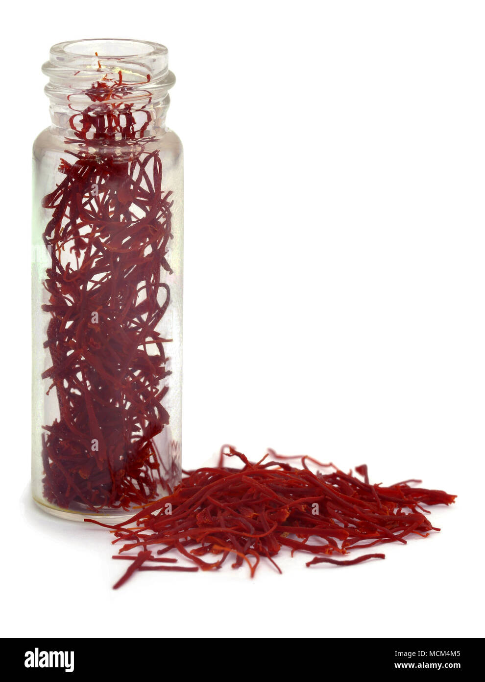 Closeup of Saffron in a bottle  used as food additive over white background Stock Photo
