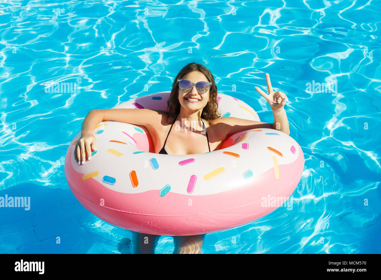 Happy woman inner tube sea hi-res stock 