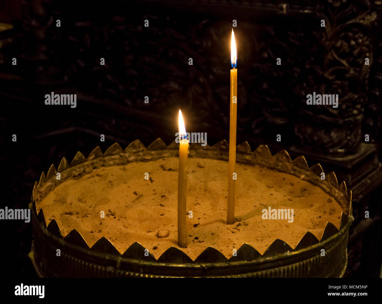 The lighted wax candles, the candles are burning in the twilight in the