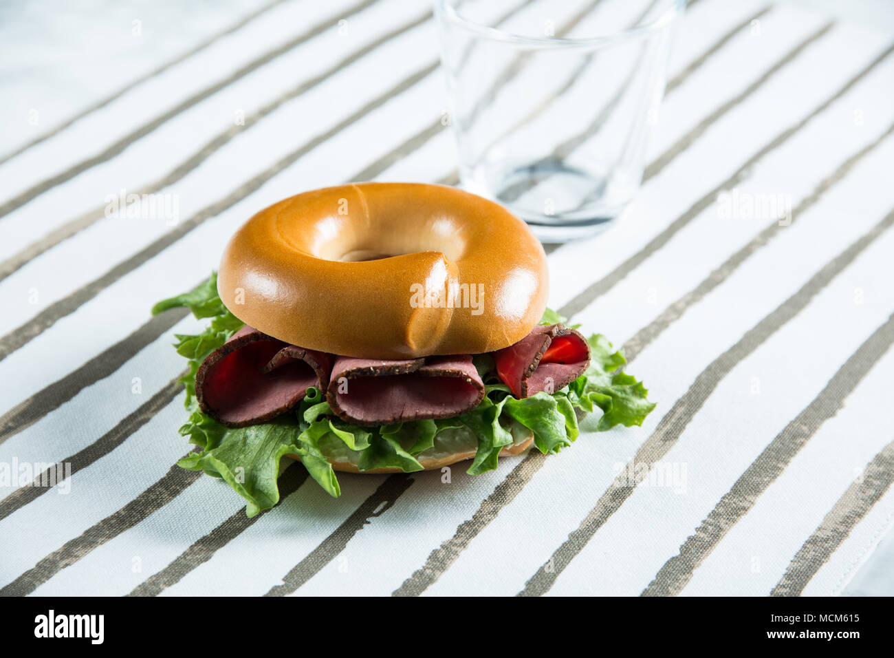 Bagel with lamb slices, salad and cream cheese. Stock Photo
