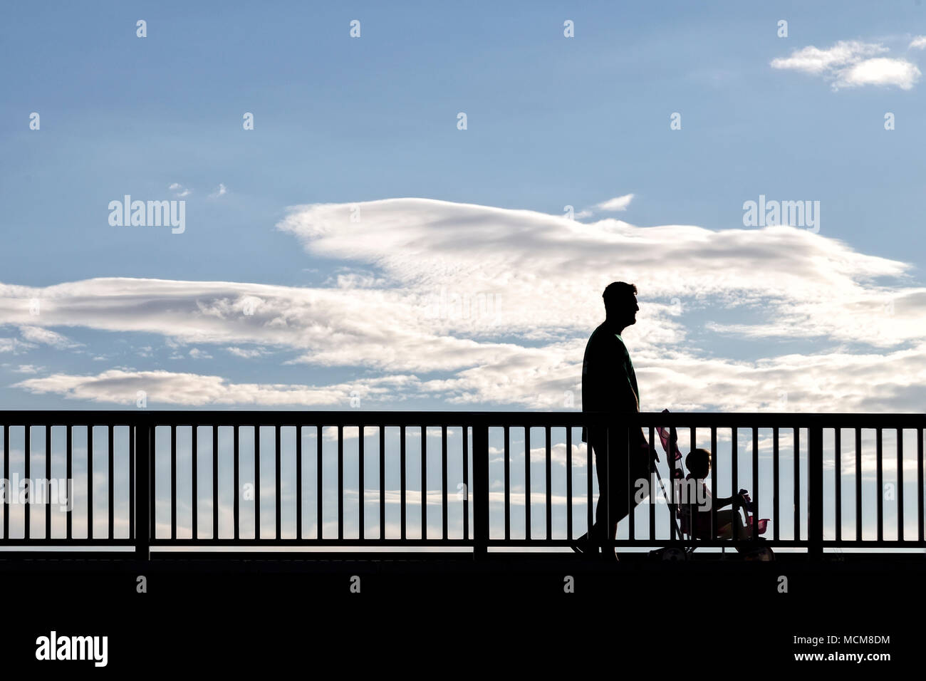 Silhouette of people walking across the bridge Stock Photo - Alamy