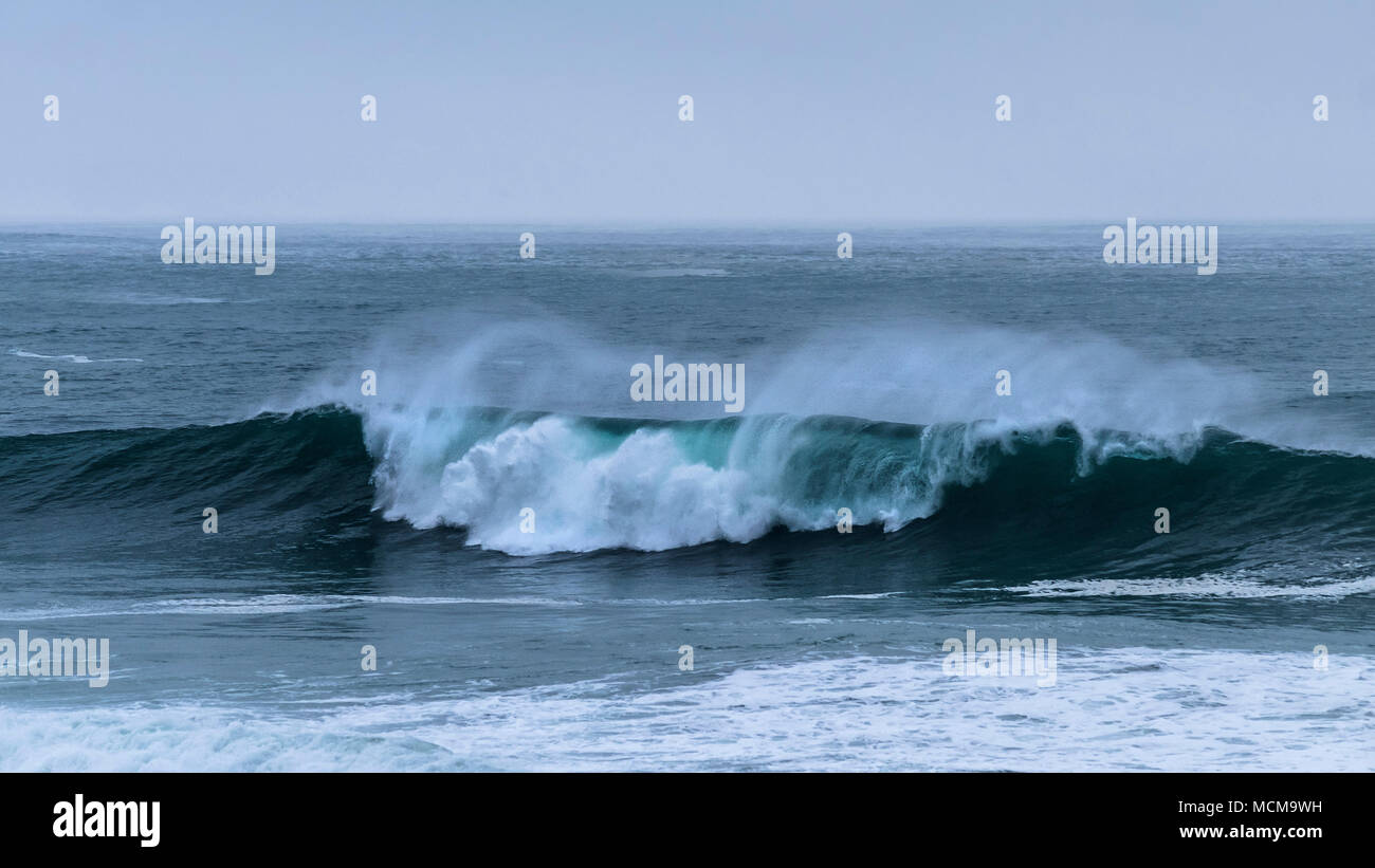 A panoramic view of wave breaking during windy cold weather conditions at Fistral in Newquay Cornwall. Stock Photo
