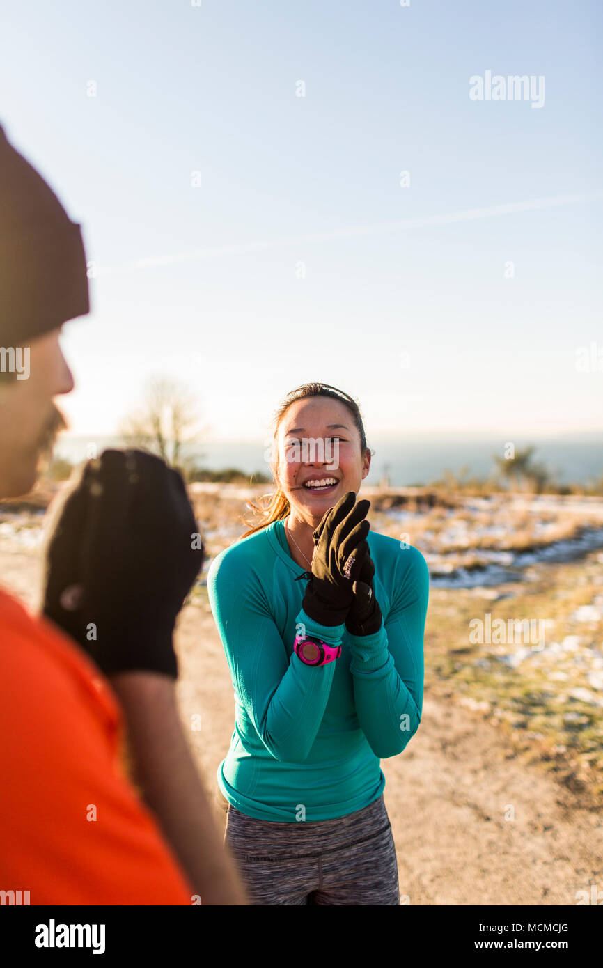 Male and female runners smiling and talking, Discovery Park, Seattle, Washington State, USA Stock Photo
